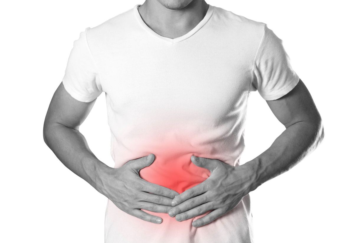 The man is holding his stomach. Abdominal pain. The hearth is highlighted in red. Close up. Isolated on white background. The man is holding his stomach. Abdominal pain. The hearth is highlighted in red. Close up. Isolated on white background.